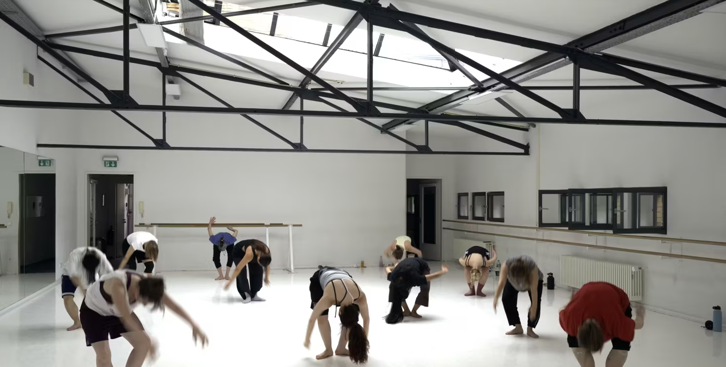 Still image of dancers training in a studio